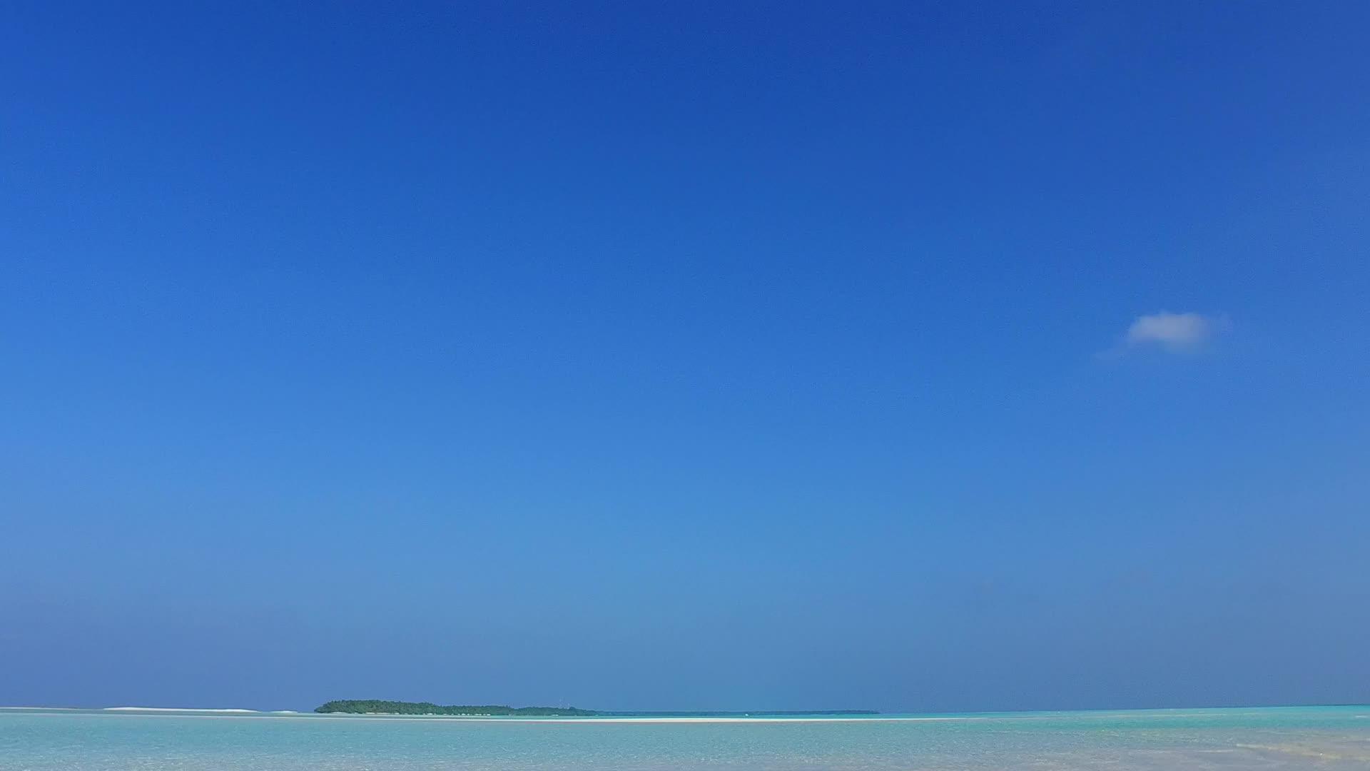 沿着浅海和白沙的背景在度假胜地附近的宁静海滩上旅行视频的预览图