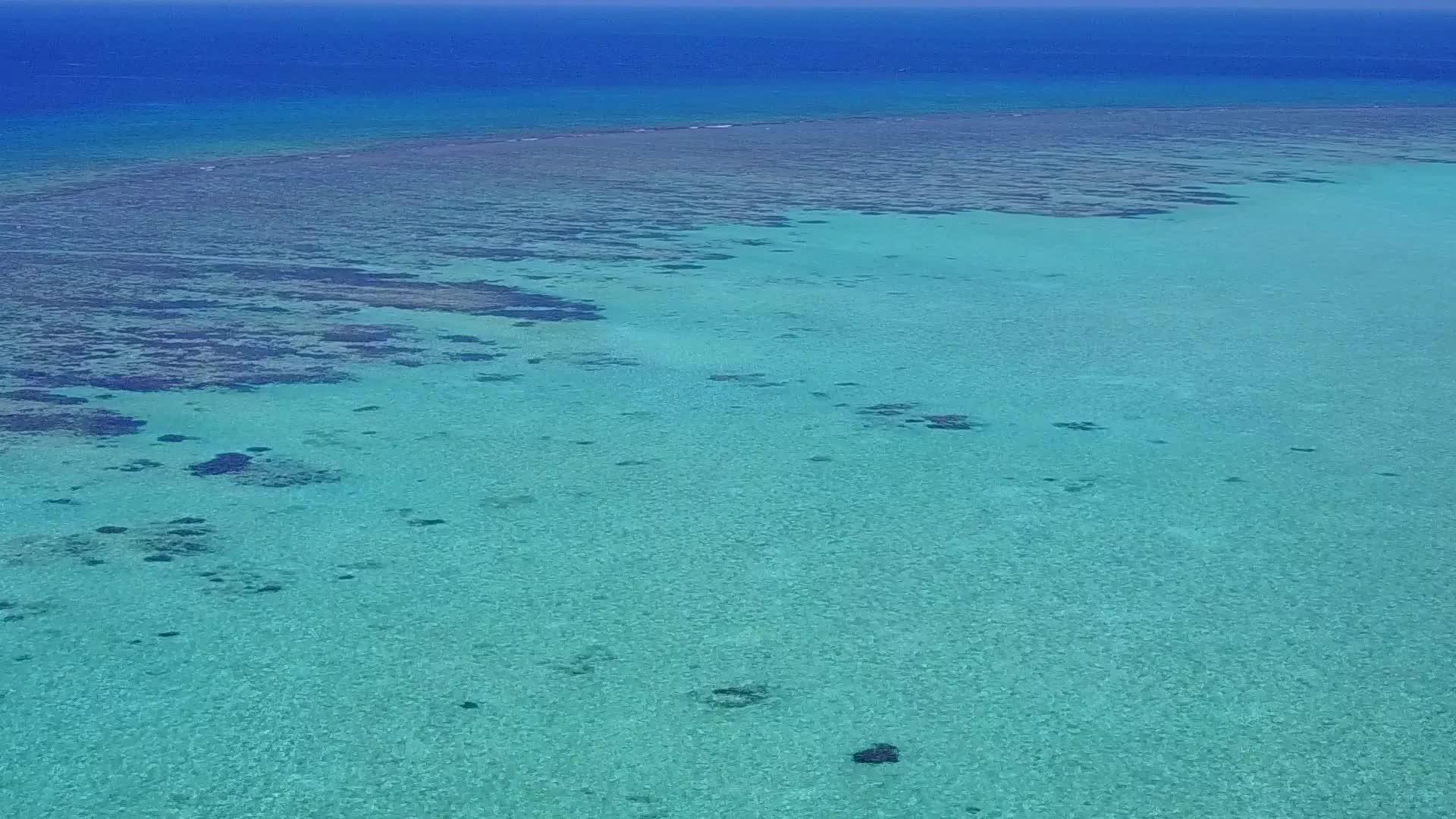 日出后放松海湾海滩旅游蓝色环礁和白色沙沙背景视频的预览图