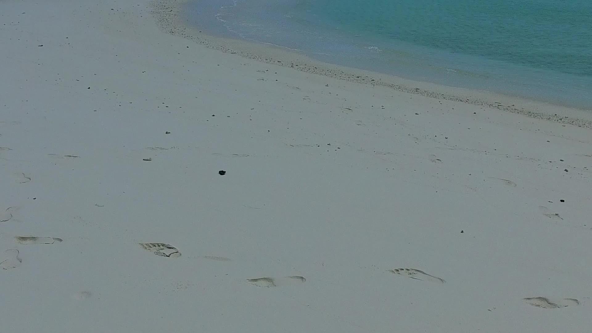阳光下白沙背景蓝海田园诗般的海滩度假温暖全景视频的预览图