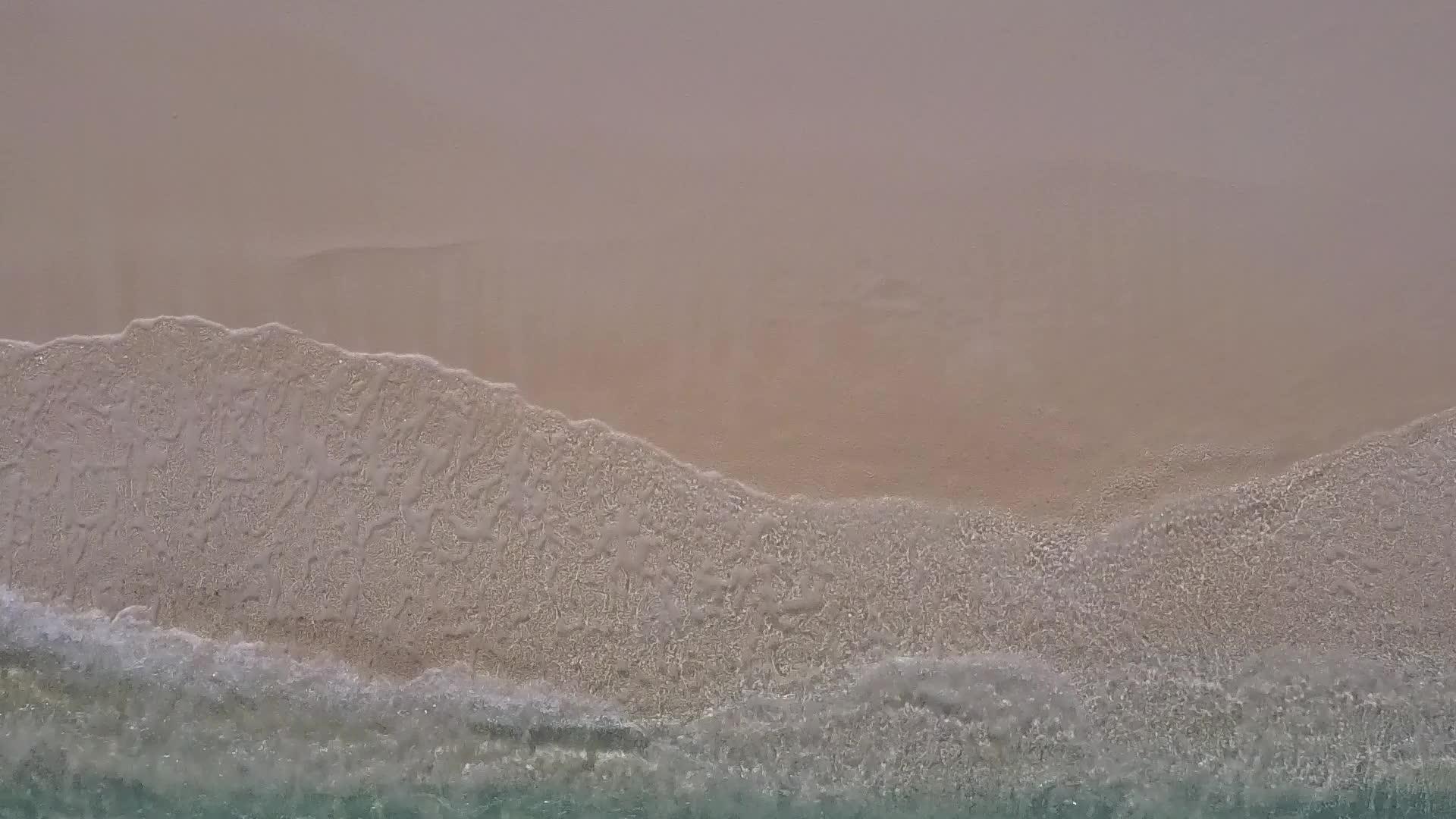 清澈的海洋和波浪附近的白沙背景完美的海景海滩之旅视频的预览图