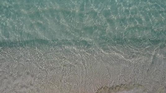 在珊瑚礁附近有白色沙滩背景的蓝色海洋豪华度假海滩阳光明媚的风景视频的预览图