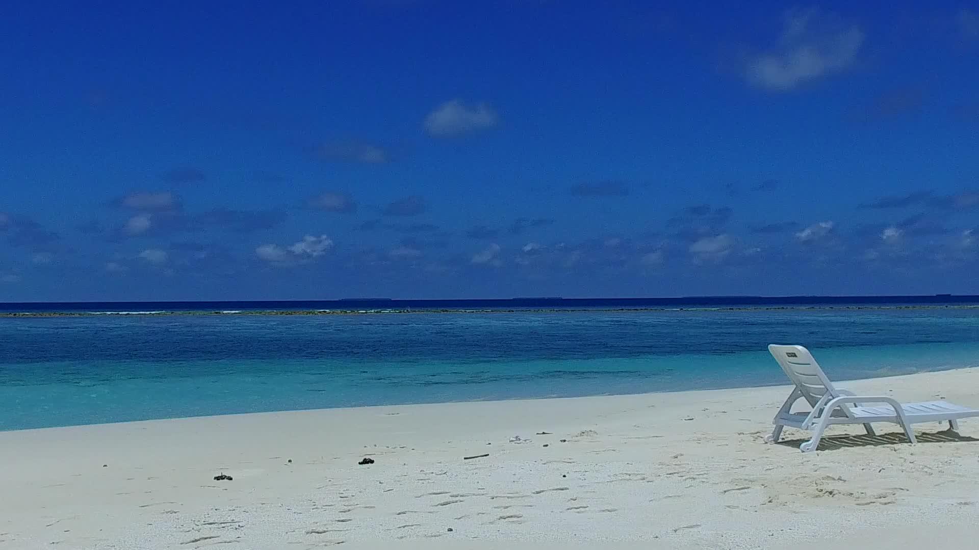 以蓝海和阳光下的白沙为背景打破了宁静海湾海滩的夏日风光视频的预览图