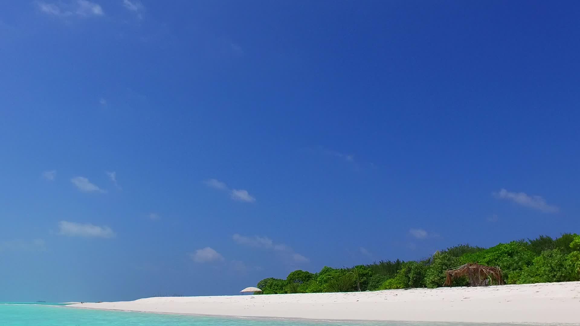 环礁湖海滩全景沿蓝海旅游在冲浪附近有浅沙背景视频的预览图