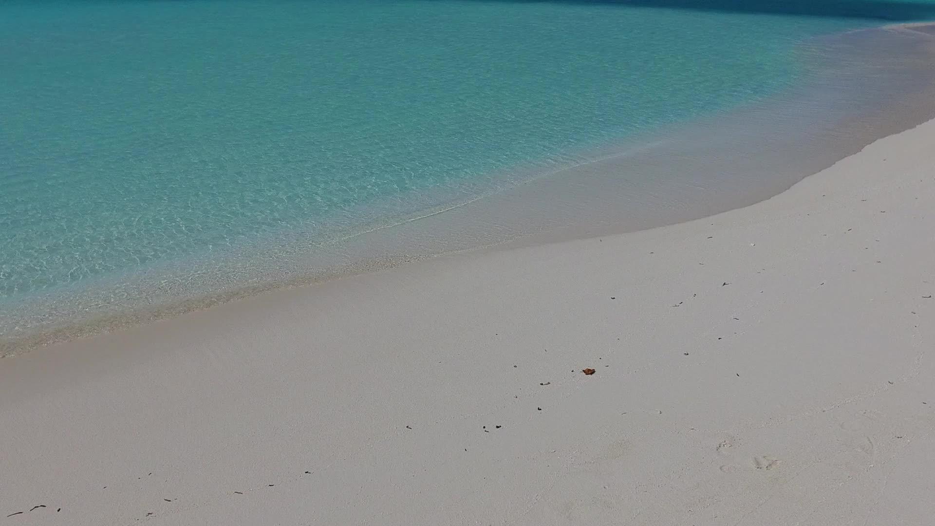 蓝绿色的大海打破了天堂湾海滩沙巴附近的白色沙子背景视频的预览图