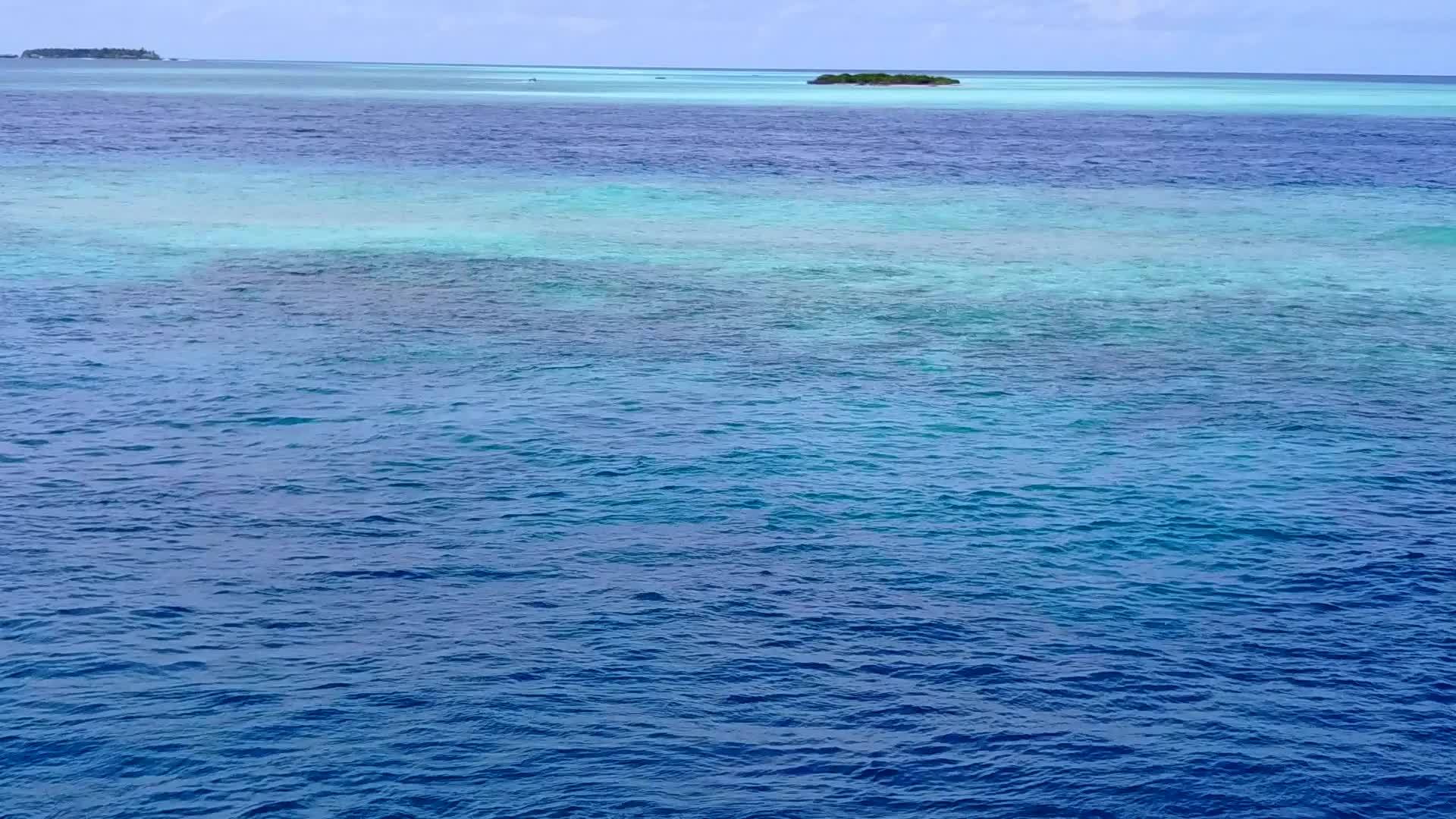 蓝色海洋日出后蓝色海洋以白色沙滩为背景视频的预览图