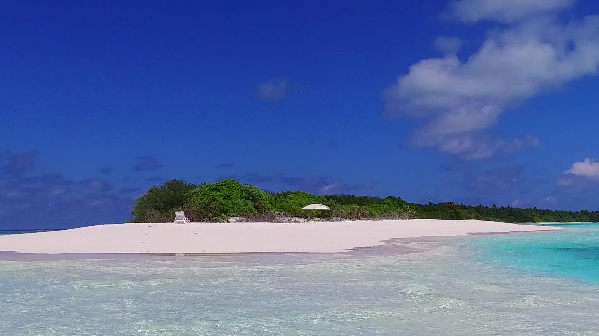 珊瑚礁附近的白沙背景蓝绿色泻湖复制美丽的沿海海滩航行视频的预览图
