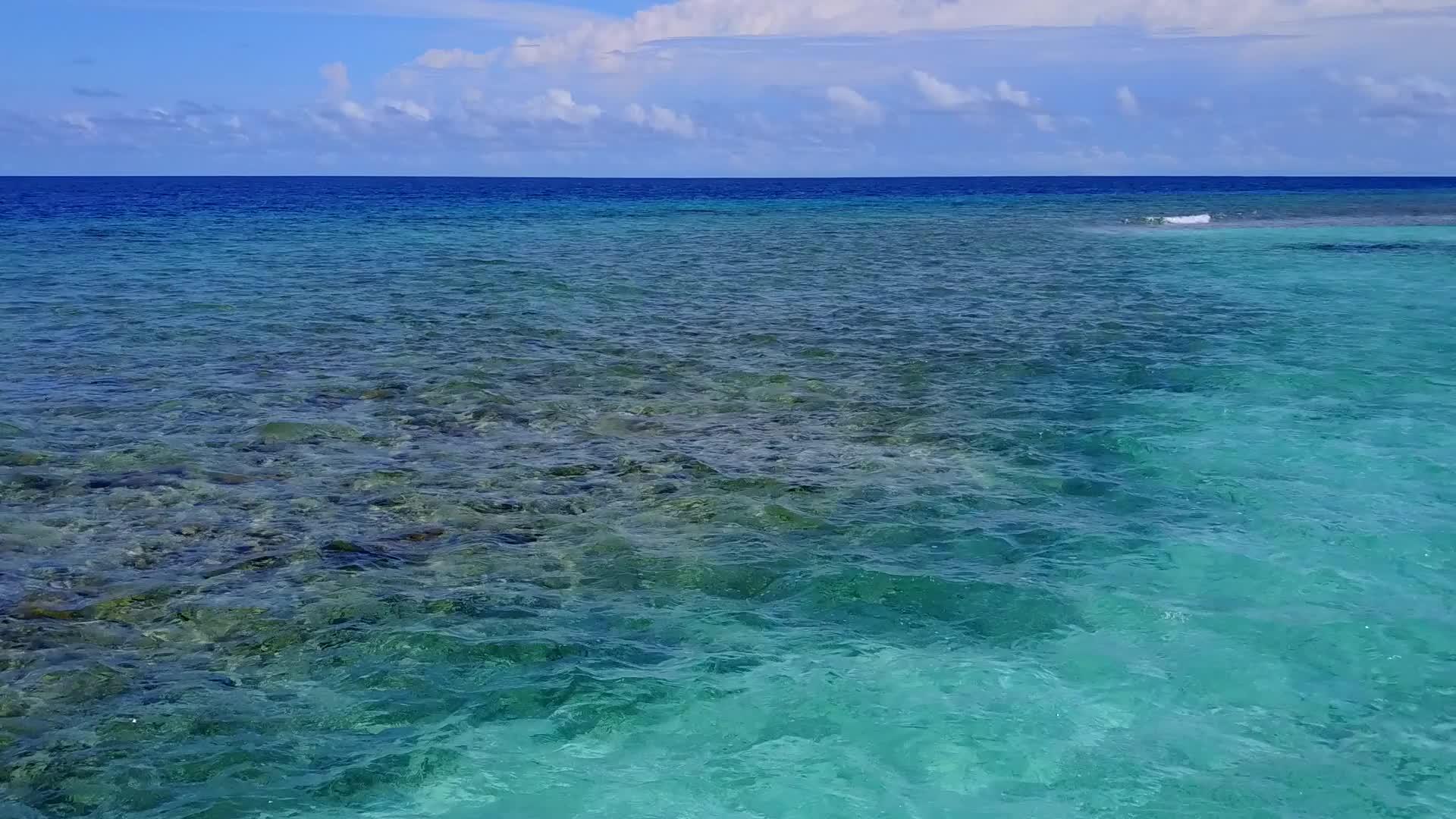 从蓝海到珊瑚礁附近的美丽的海岸海滩宽角旅行视频的预览图