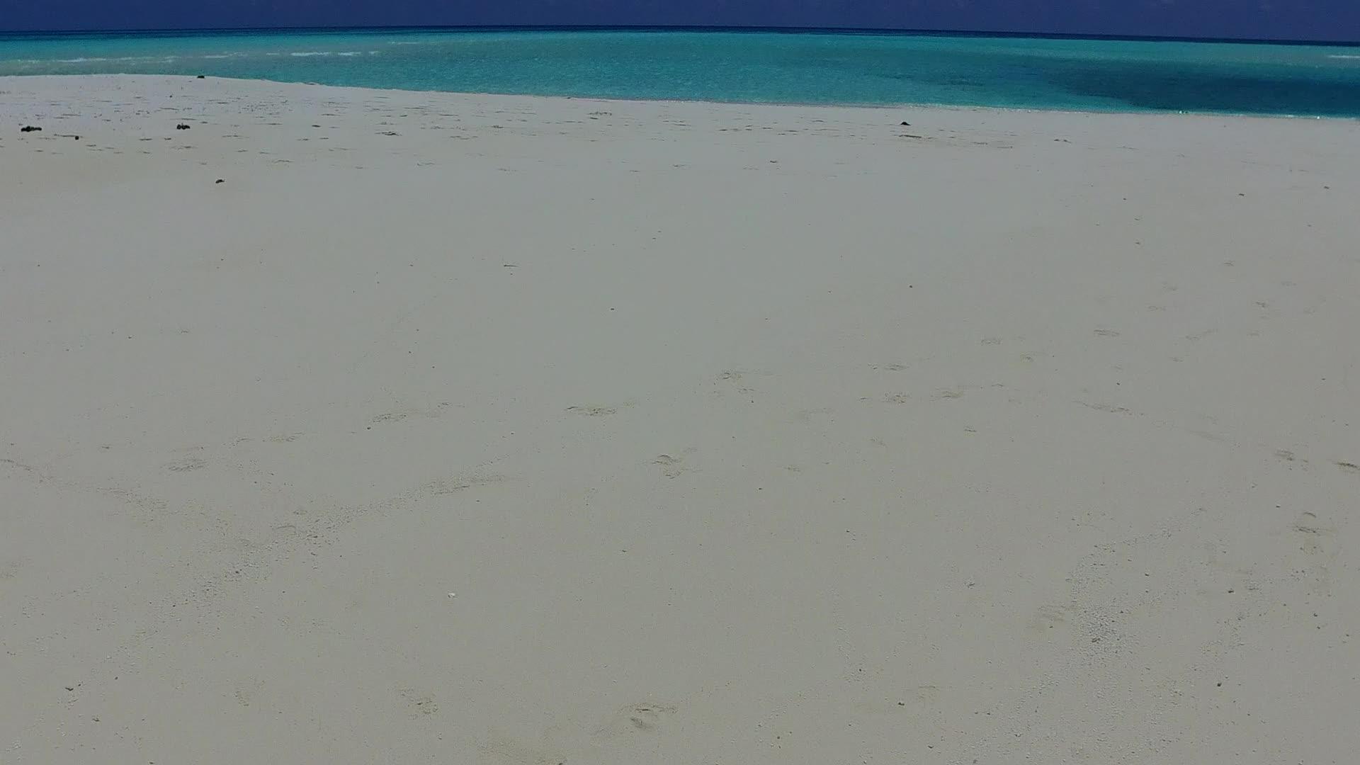 蓝绿色的大海和近波边的白色沙底背景阳光明媚视频的预览图