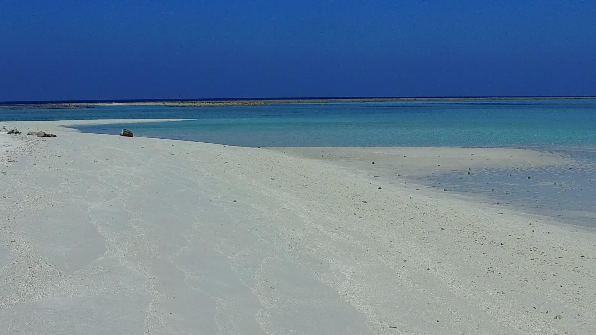 海岸堤岸被绿色的环礁湖和棕榈树附近的白色沙滩背景断裂视频的预览图