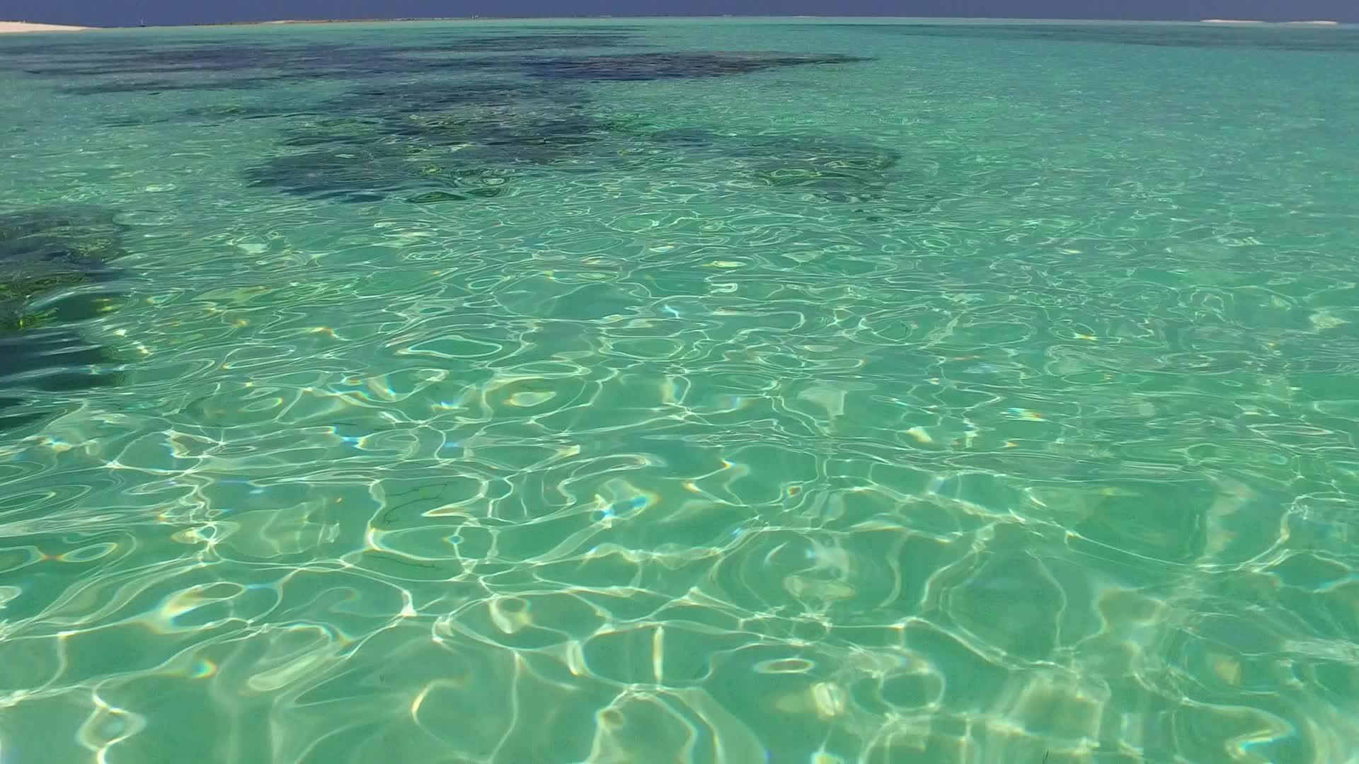 阳光下的白色沙滩背景下的水蓝色大海轻松度假海滩航行阳光视频的预览图