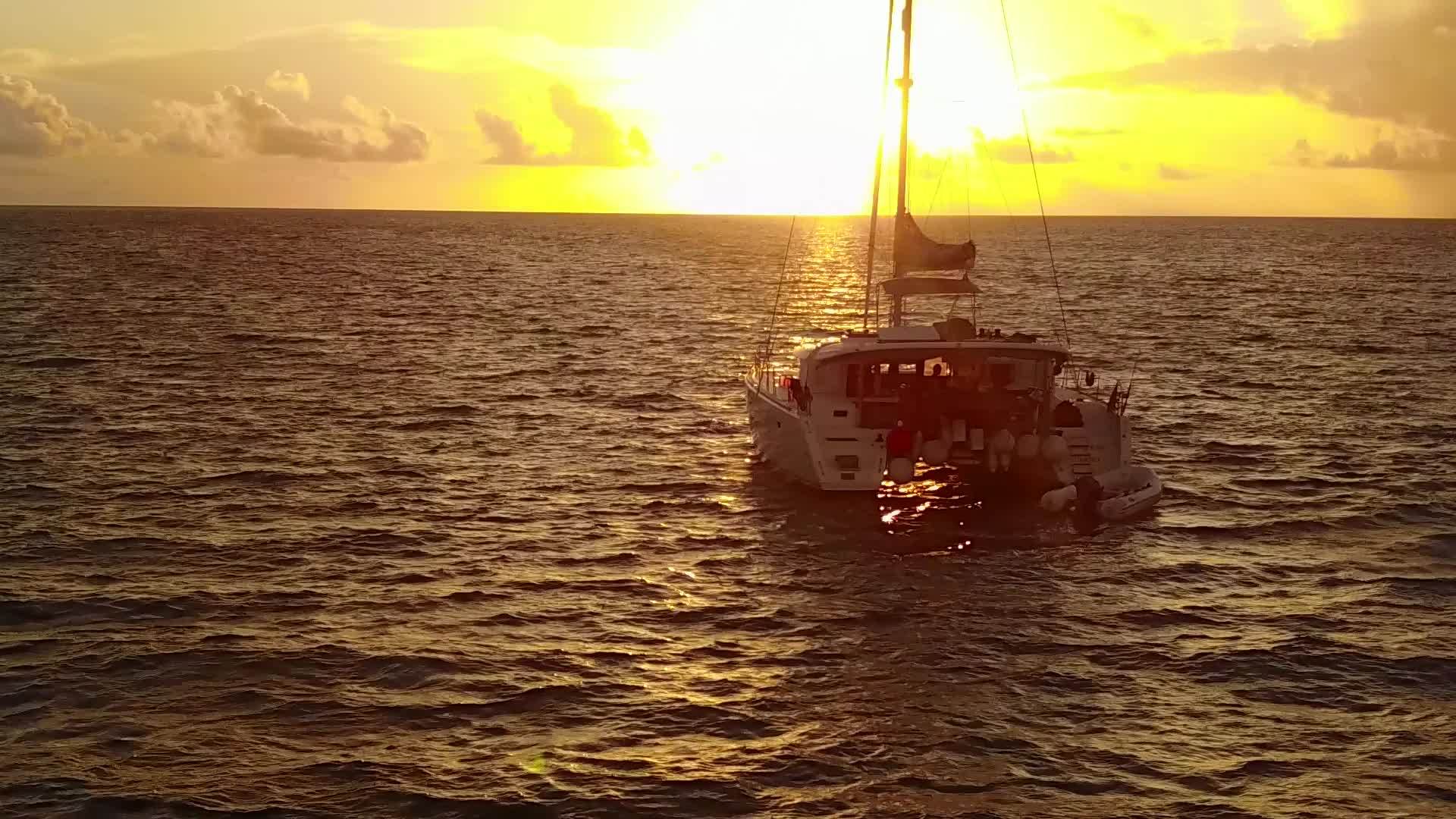 日落前蓝色的海洋以蓝色的海洋和白色的沙子为背景在封闭而安静的岛屿上航行视频的预览图