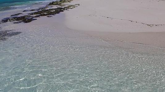在蓝色海洋和浅沙附近冲浪的背景下海岸海滩的航程很宽视频的预览图