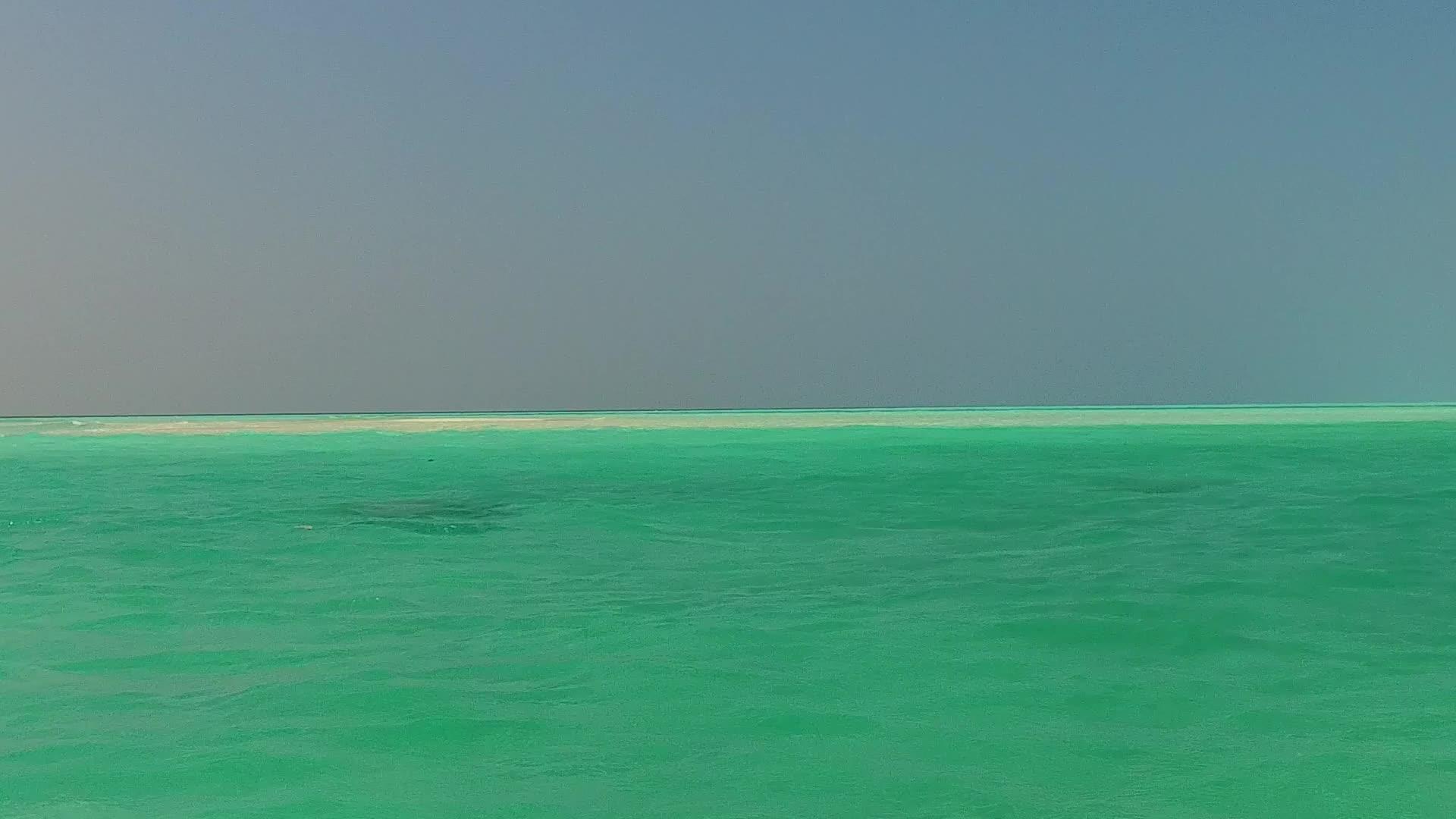 蓝色海洋和日出后的白色海滩背景视频的预览图