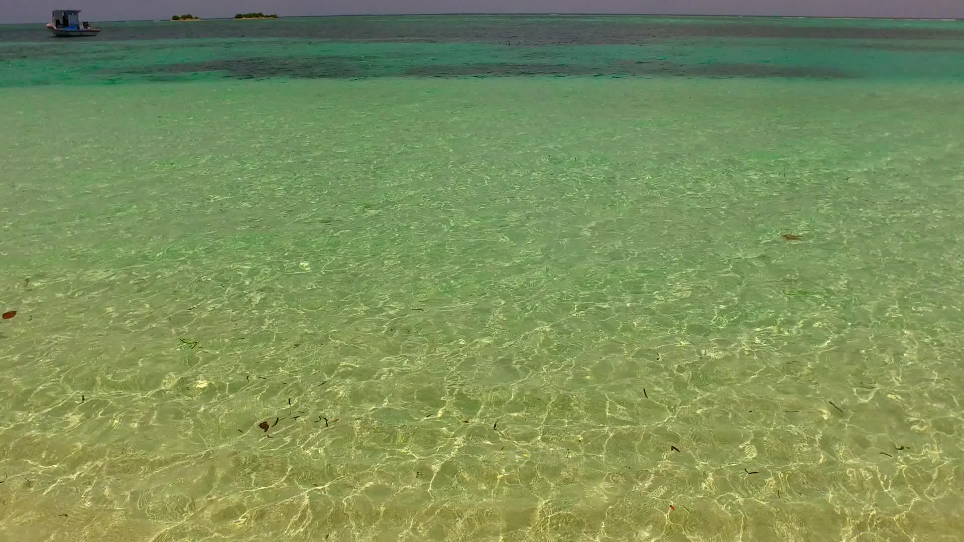 环礁湖海滩的休息是利用水、蓝水和阳光下的白沙空气复制的视频的预览图
