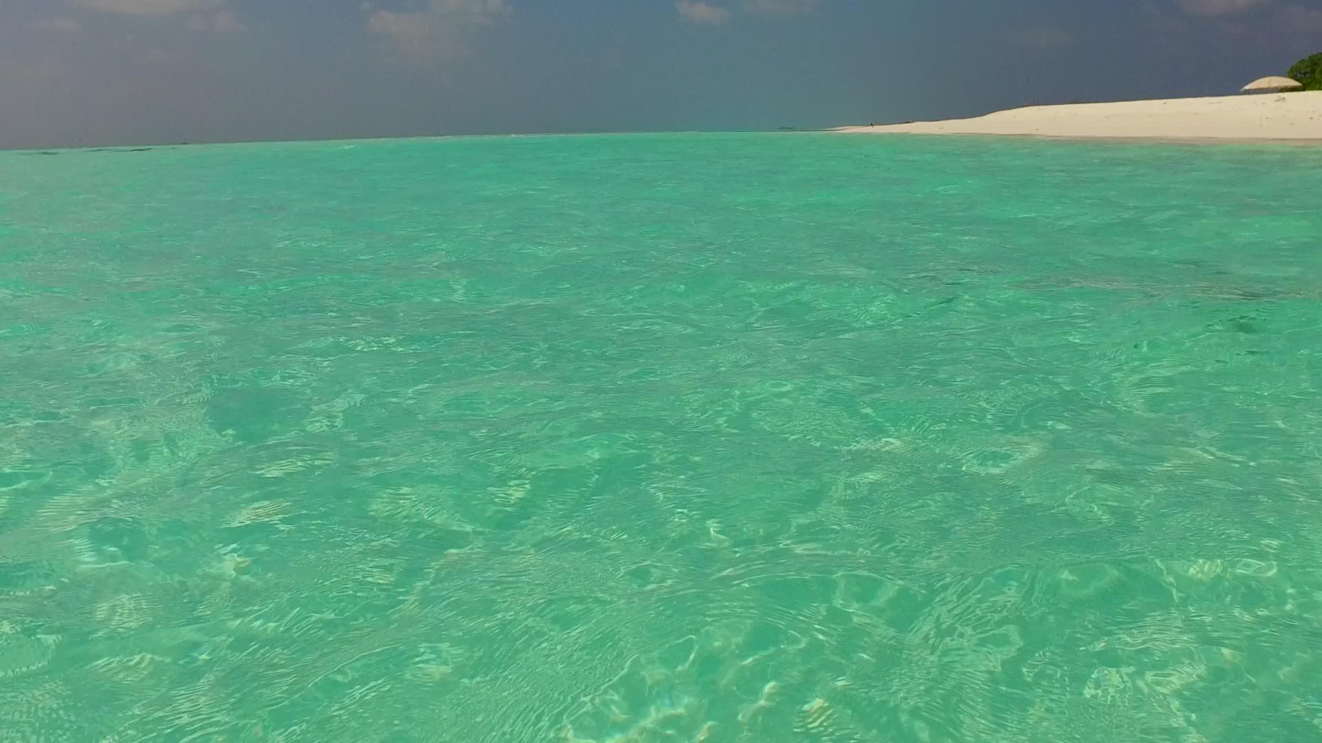 日出后长边海滩以蓝水和白色沙底为背景度假视频的预览图