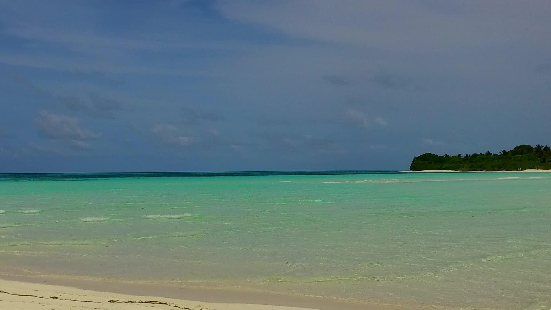 白色沙滩靠近海浪背景蓝色泻湖豪华海景海滩度假视频的预览图