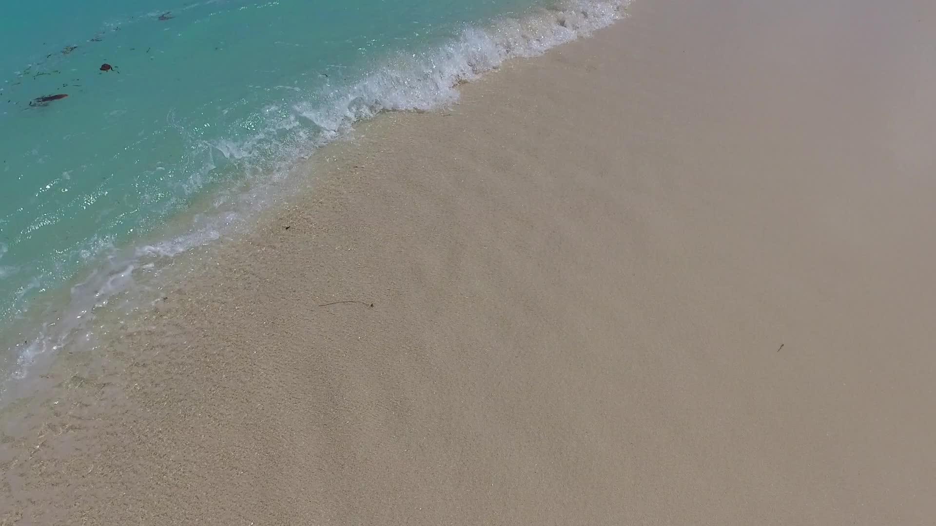 阳光明媚的宁静度假胜地海滩被蓝海打破阳光下有白色的沙子视频的预览图