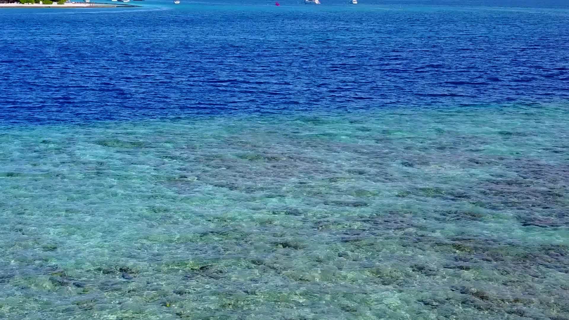 阳光明媚、寒冷的环礁湖海滩的天空被蓝色的大海打破了太阳下有白色视频的预览图