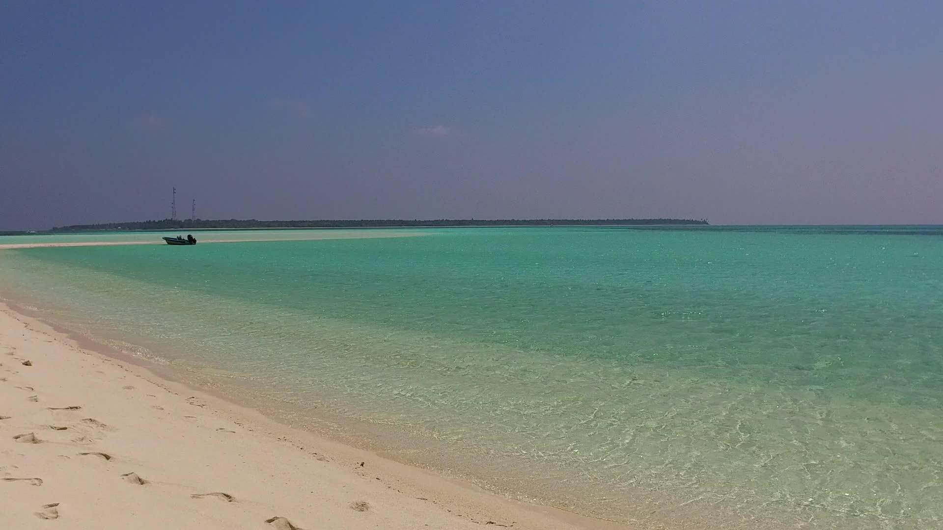 宁静的海滩野生以蓝色的水和接近冲浪的白色沙滩为背景视频的预览图