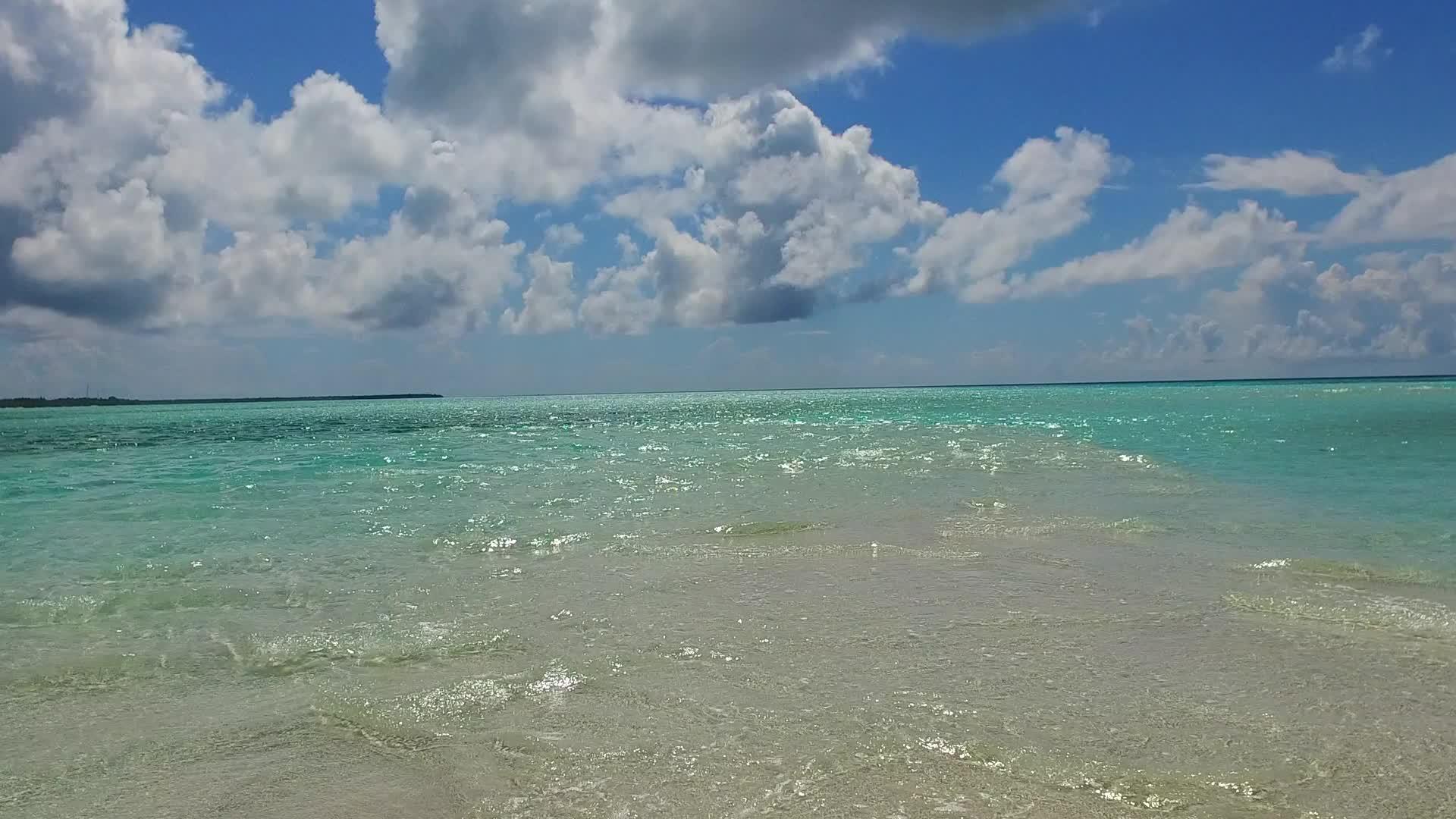 在蓝绿色的海洋中航行棕榈树附近有一个白色的沙底背景视频的预览图