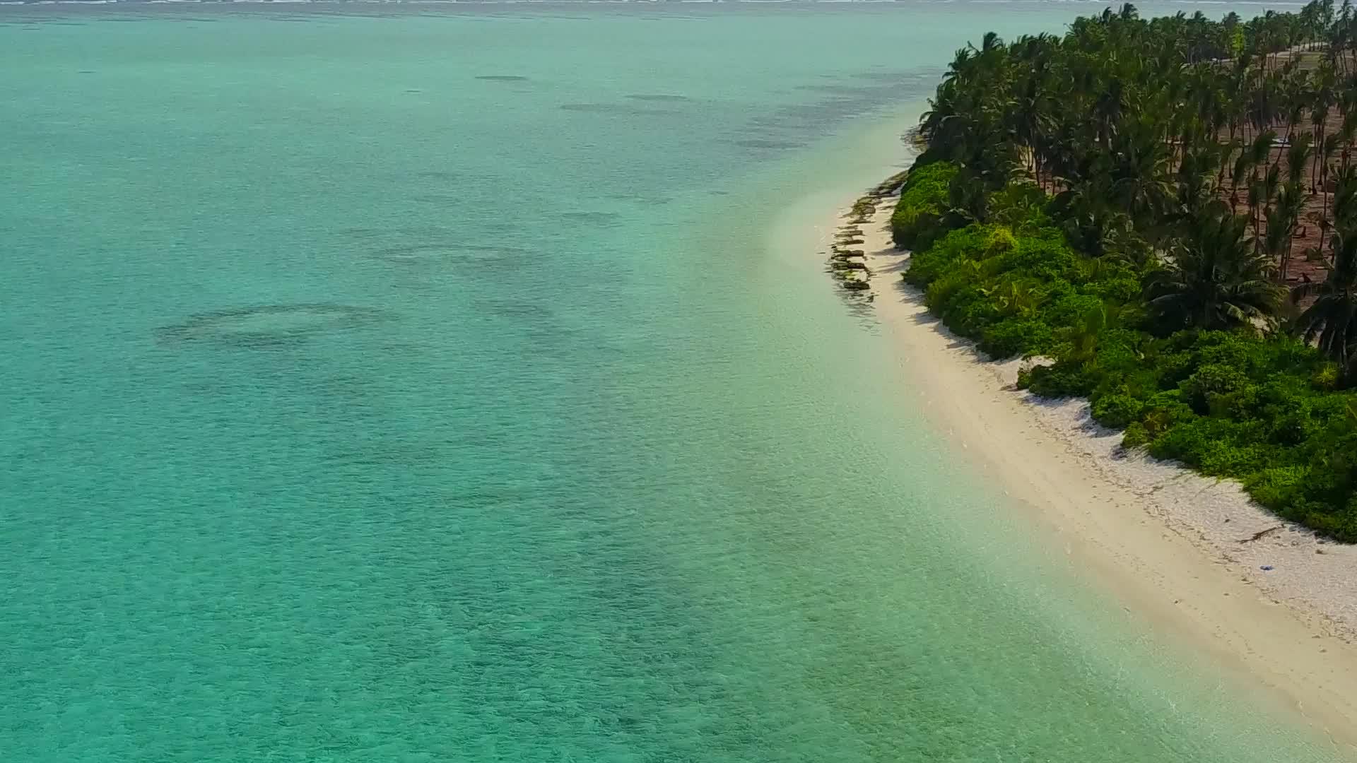 蓝色的大海和冲浪附近的白色海滩有着完美的背景视频的预览图