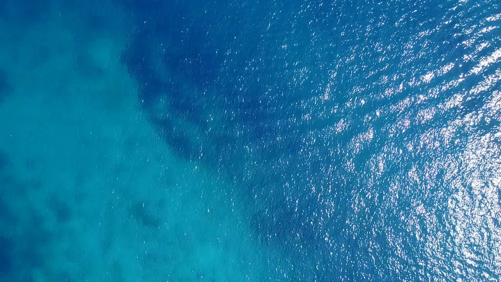 蓝色的水和浅沙背景在度假胜地附近美丽的海滩旅游视频的预览图