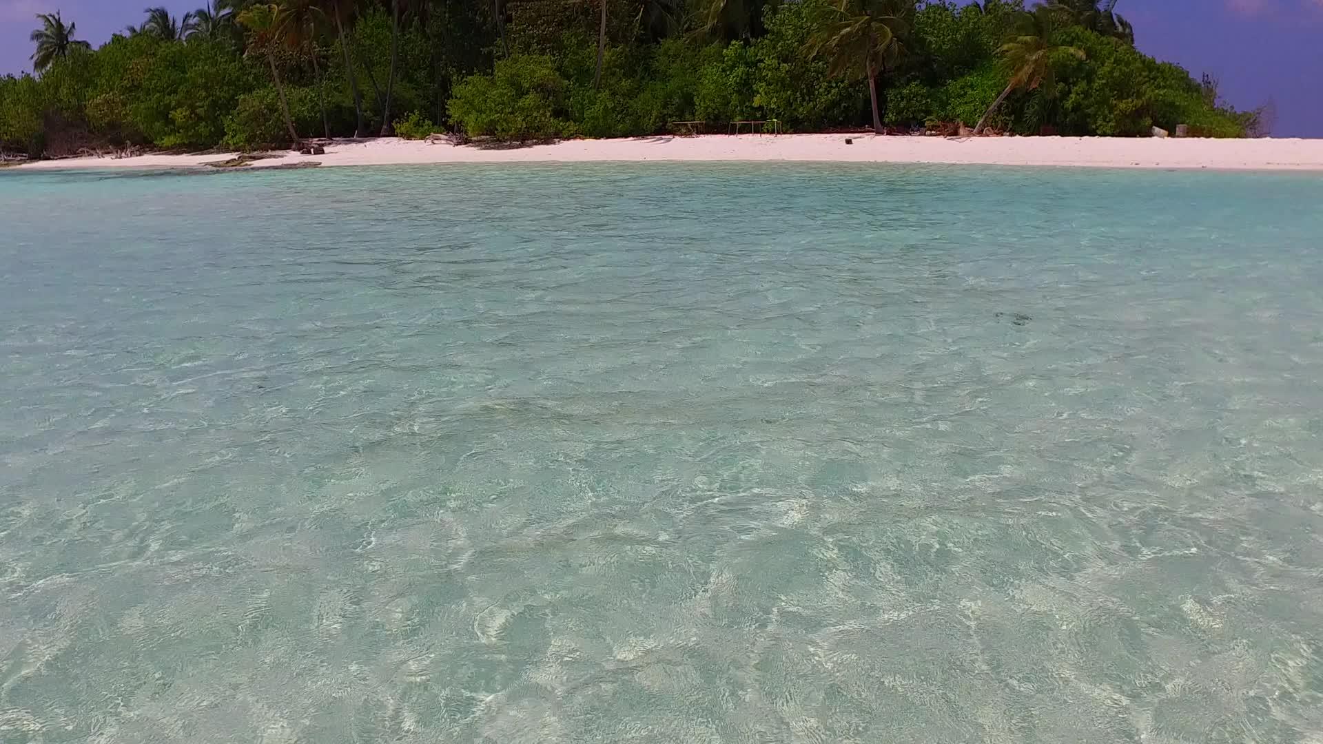 海浪附近的松绿环礁湖和白色海滩背景热带海岸海滩时间视频的预览图