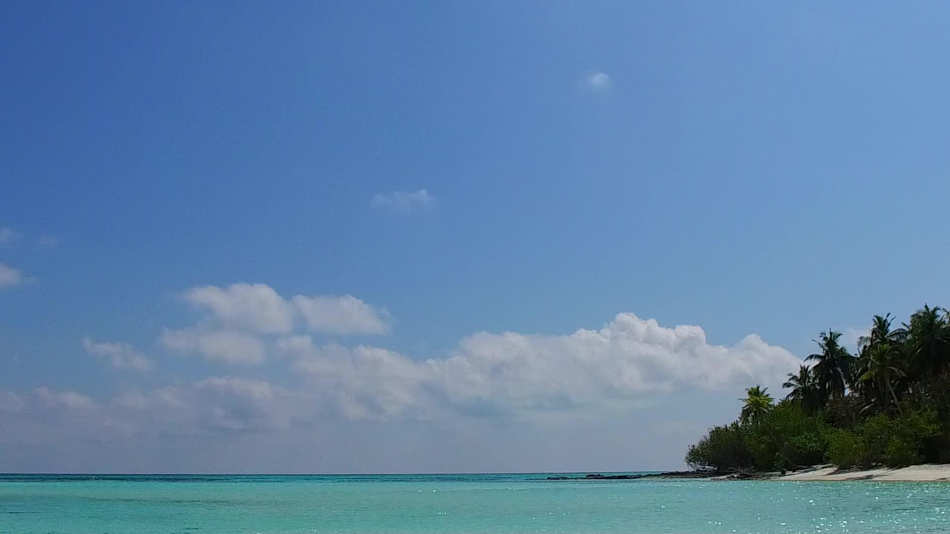 环礁湖海滩通过蓝色大海打破了白色沙子的背景视频的预览图