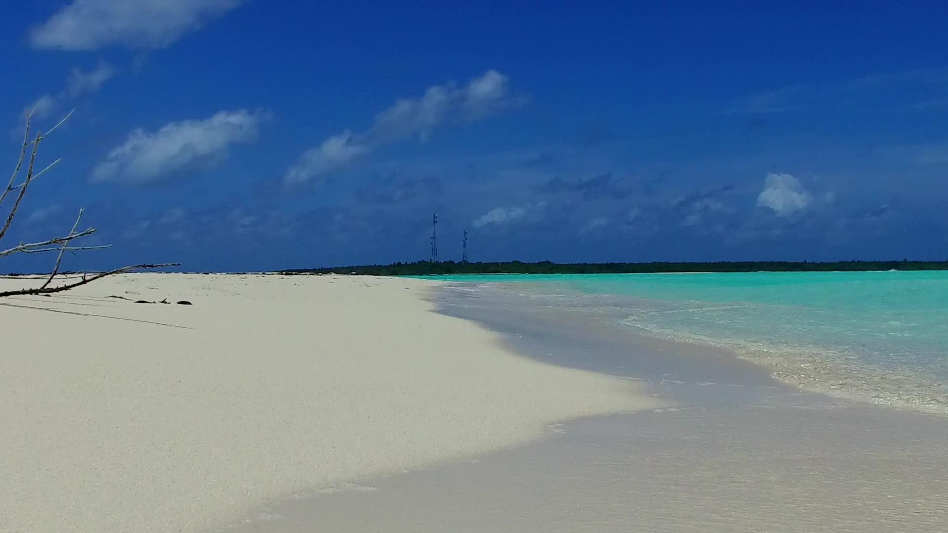 通过蓝绿色的水和度假胜地附近的白沙背景封闭海景安静视频的预览图