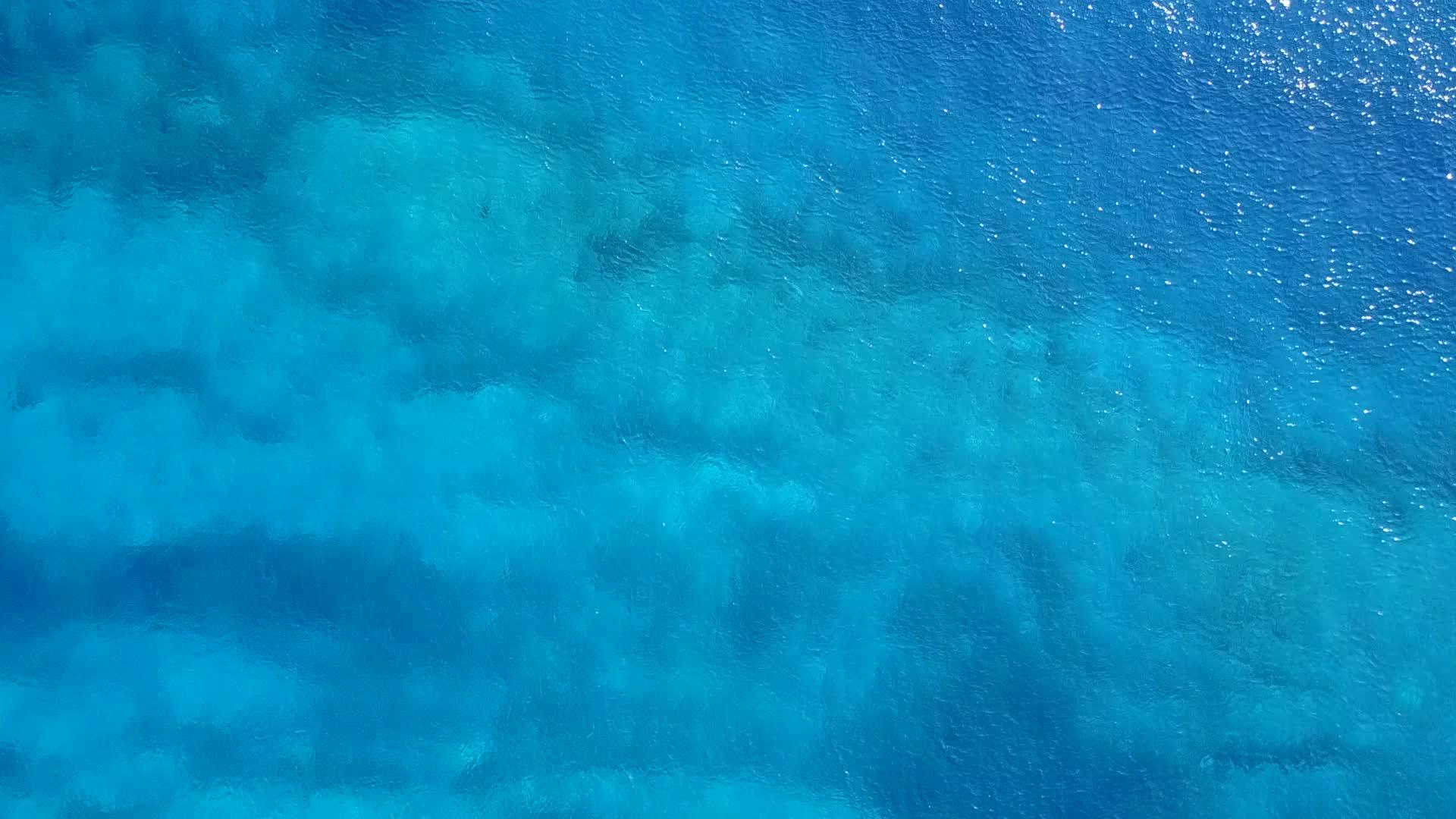 阳光下明亮的沙色背景下的蓝海美丽的海滩度假广角景观视频的预览图