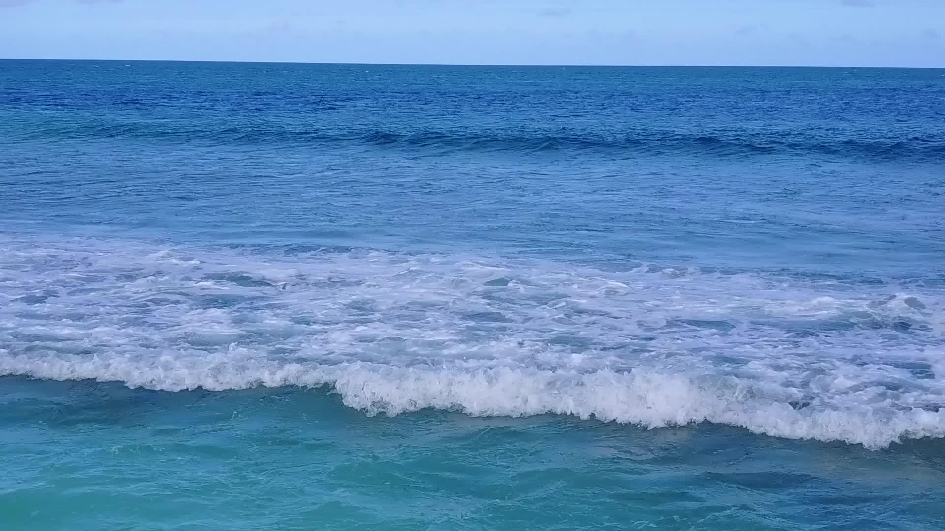 利用清水和明亮的海滩背景在冲浪附近复制安静的海滩野生视频的预览图