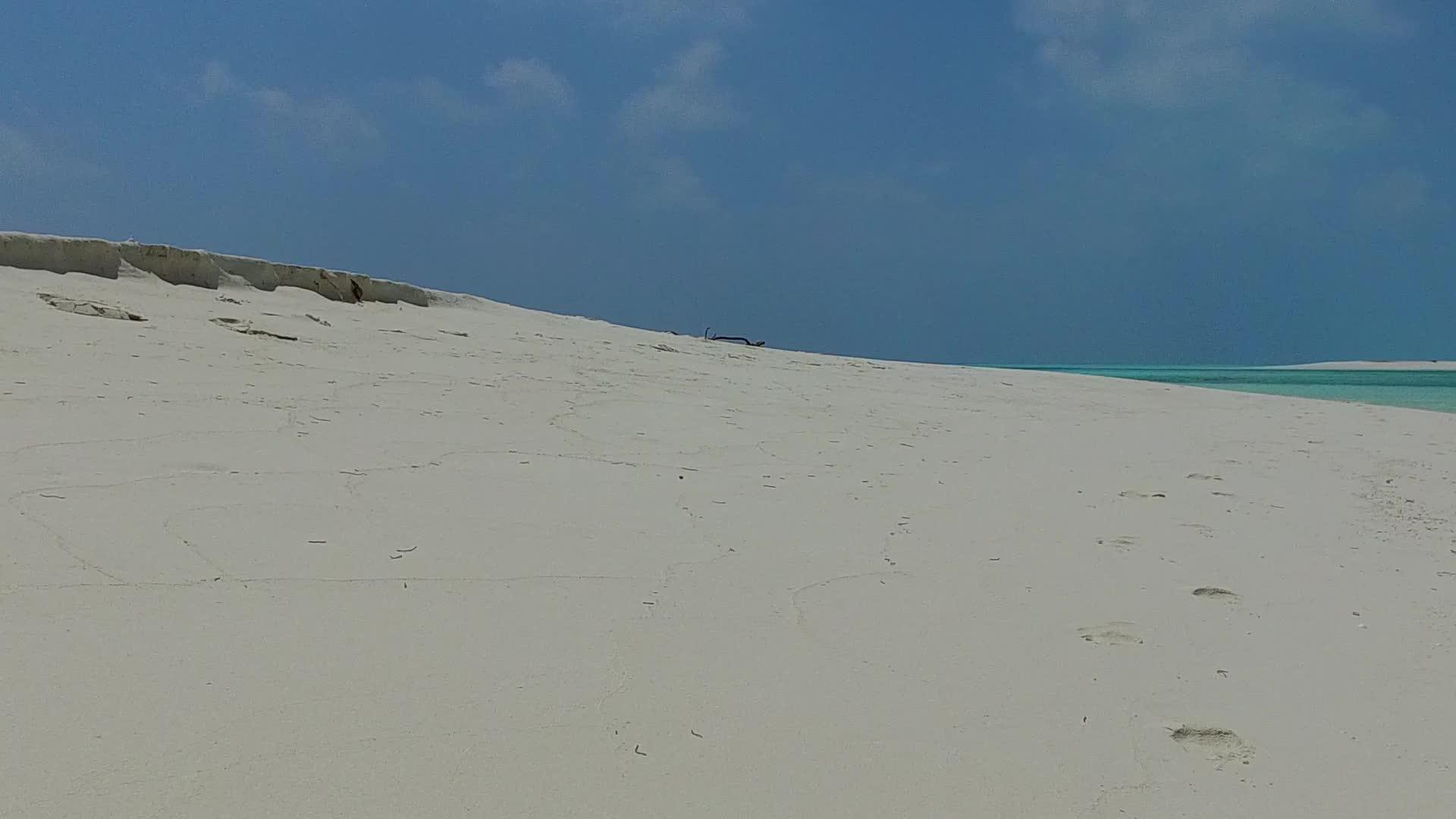 清澈的海水和明亮的沙子在阳光下的背景复制了热带海岸线海滩的航行视频的预览图