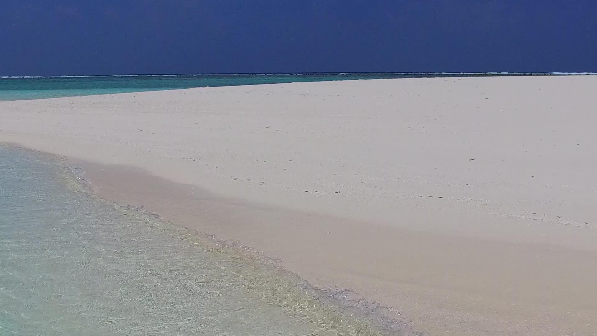 阳光明媚的海滨海滩以蓝海和阳光下的白沙为背景视频的预览图
