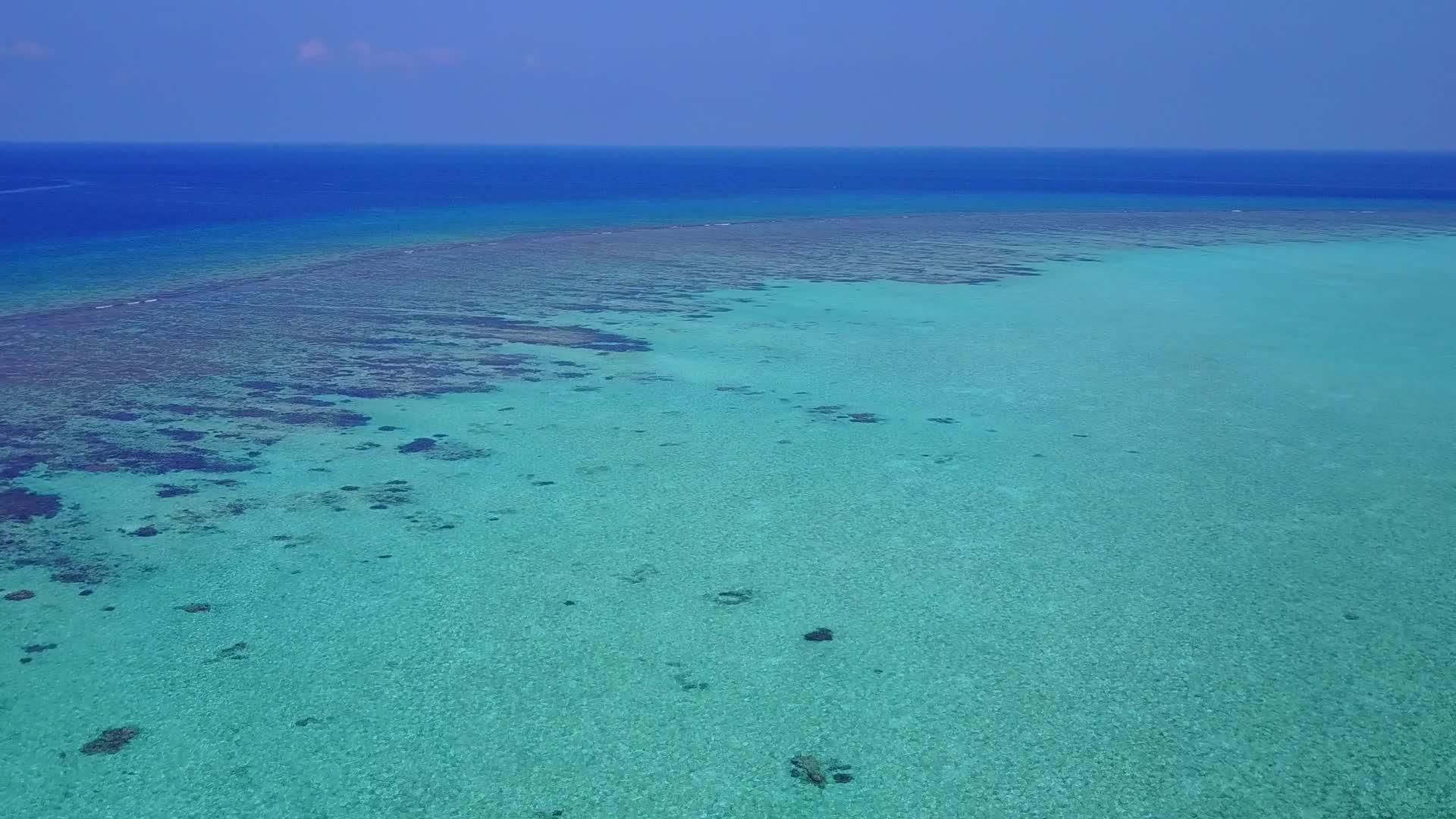 水蓝环礁湖和阳光下白色沙滩的完美背景视频的预览图