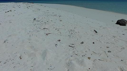 在棕榈树附近的蓝色海洋中有一个干净的沙底背景穿过豪华的环礁湖海滩视频的预览图