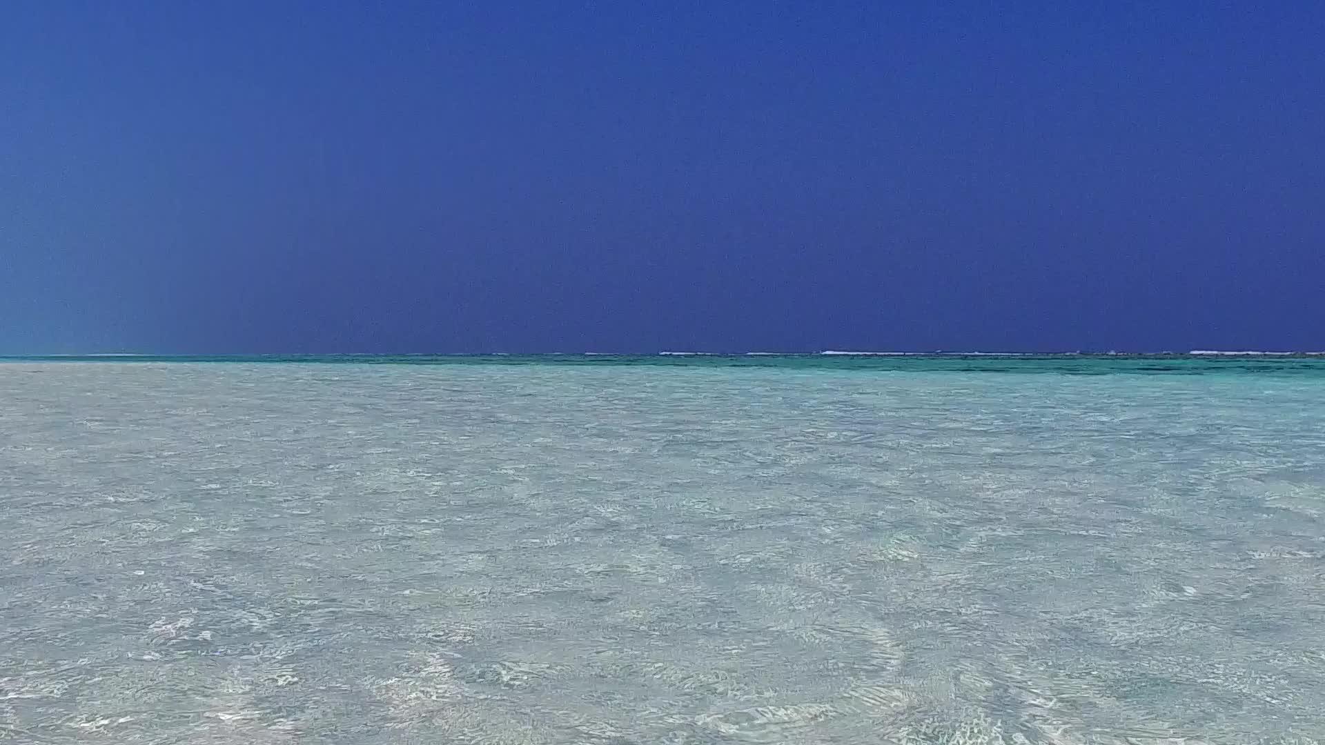 蓝色环礁湖在阳光下有一个干净的海滩背景的海边旅行视频的预览图