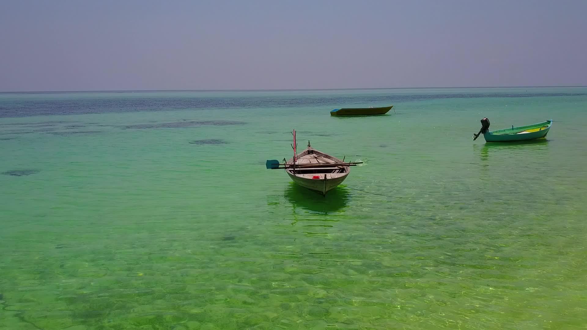 蓝绿色的大海和冲浪附近的白色海滩有着完美的背景视频的预览图