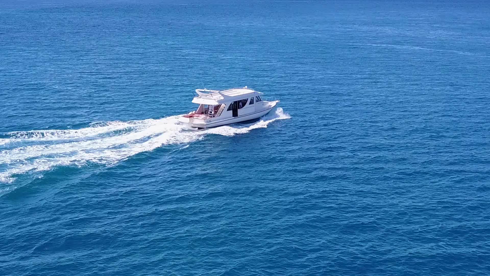 以透明的水和白沙为背景在棕榈树附近的豪华海湾沿海航行视频的预览图