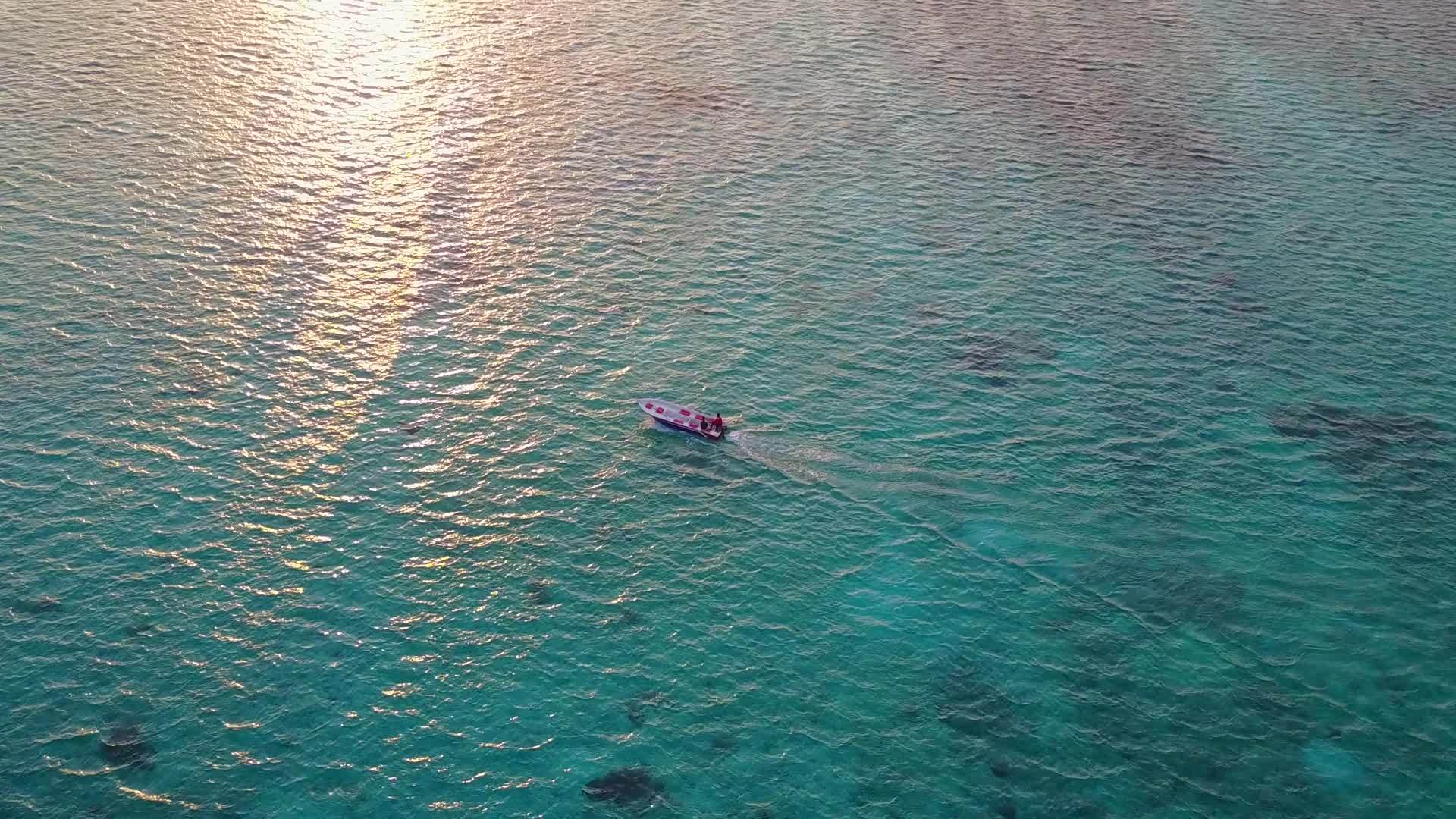 蓝绿色的海洋和日落前的浅沙背景视频的预览图