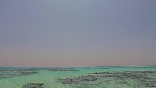 以白沙为背景的浅泻湖和珊瑚礁附近的豪华海岸线海滩时间视频的预览图