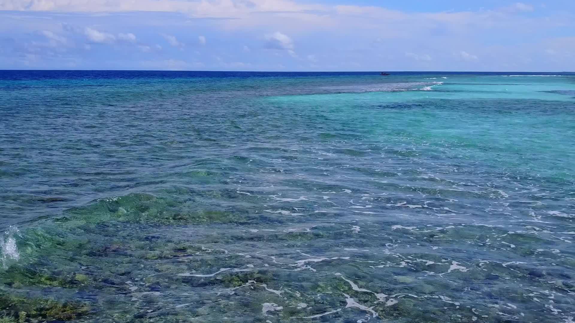 在蓝色的海洋中享受平静的海岸线海面附近有白色的沙底背景视频的预览图
