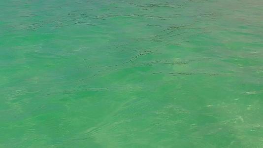 在冲浪附近有白沙背景的绿松石海洋放松海景海滩航行视频的预览图