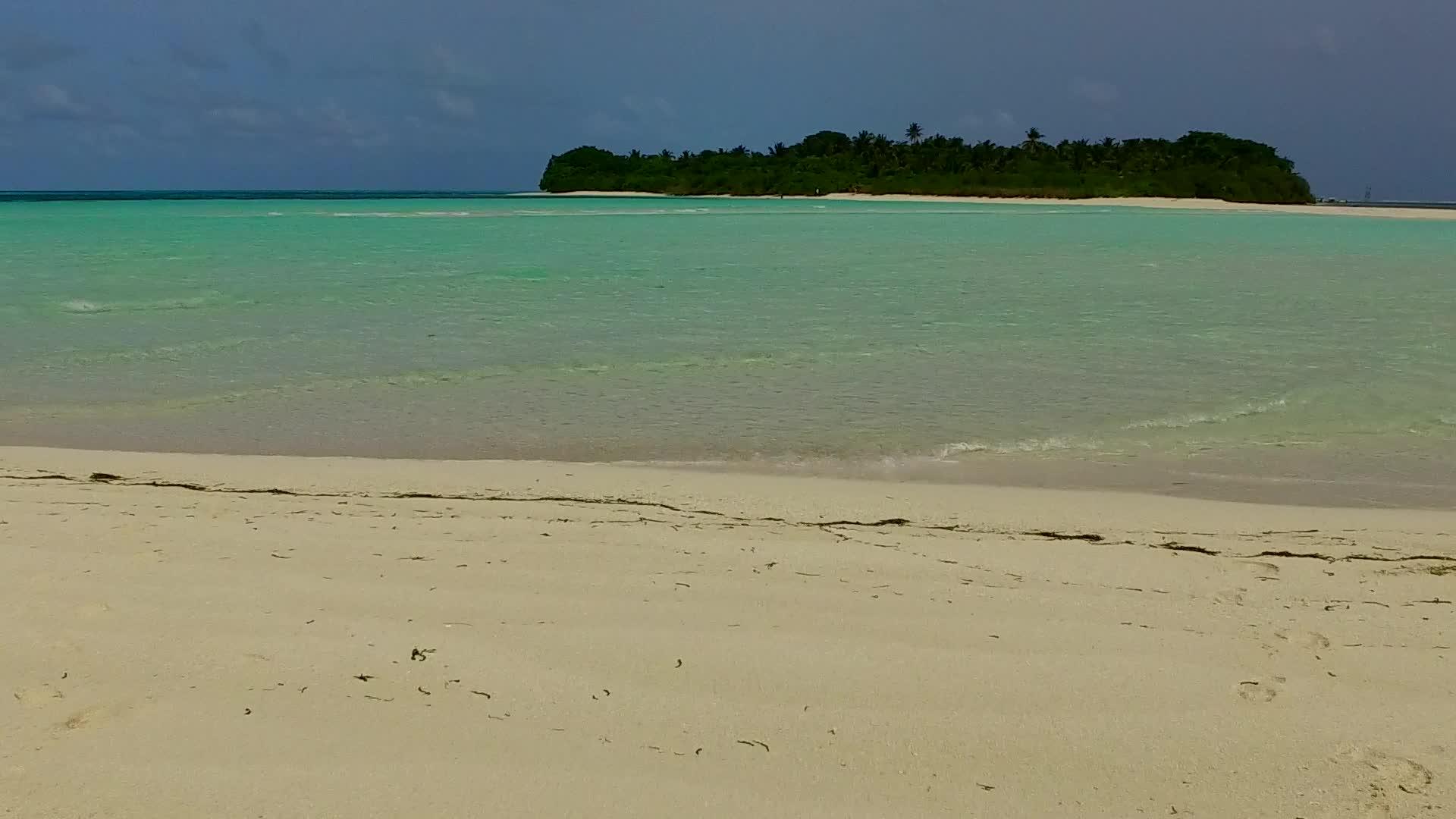 海滩附近的蓝色环礁湖和白色沙尘背景的奇怪海岸线视频的预览图