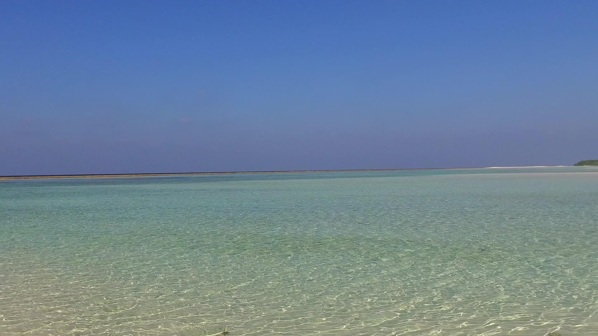日落前蓝绿色环礁湖和白色沙滩背景下的白色沙滩阳光明媚视频的预览图