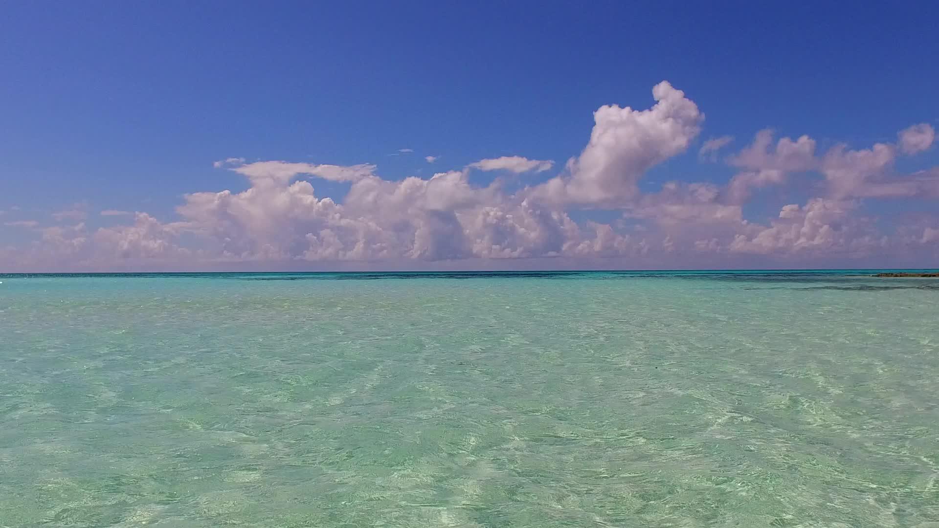 蓝色的海洋和冲浪附近清洁的海滩背景的浅蓝色海滩视频的预览图