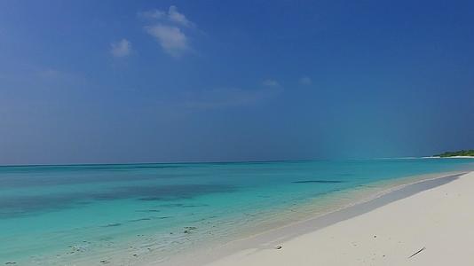 热带海岸线海滩的宽角天空冲破了阳光下白沙底下的浅白蓝水视频的预览图