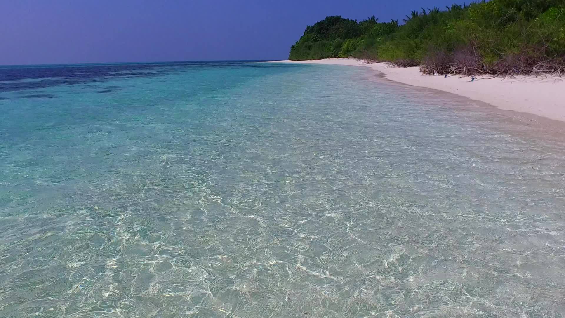 沙洲附近有蓝色的海洋田园诗般的海岸线有白色的沙沙背景视频的预览图
