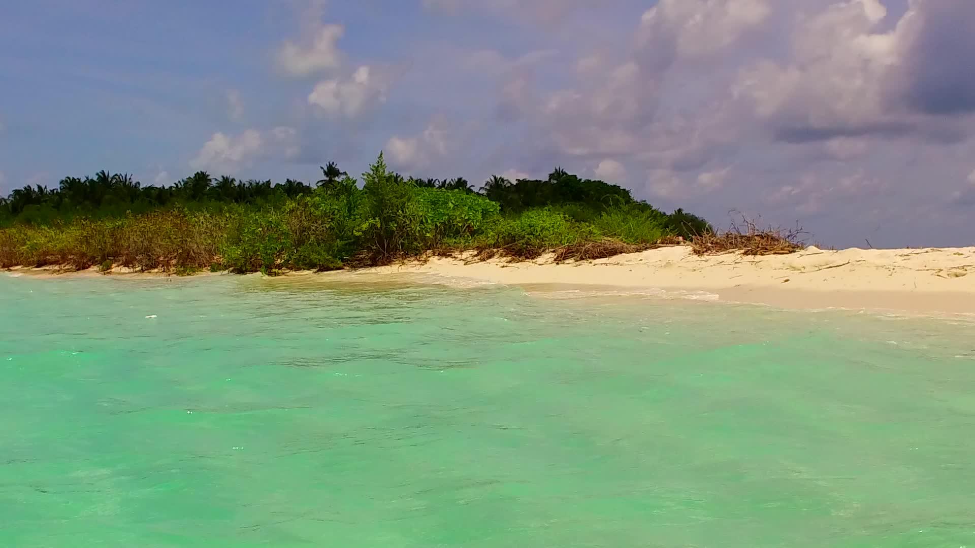 靠近海浪的白色沙滩背景下的水蓝色泻湖空荡荡的美丽岛屿视频的预览图
