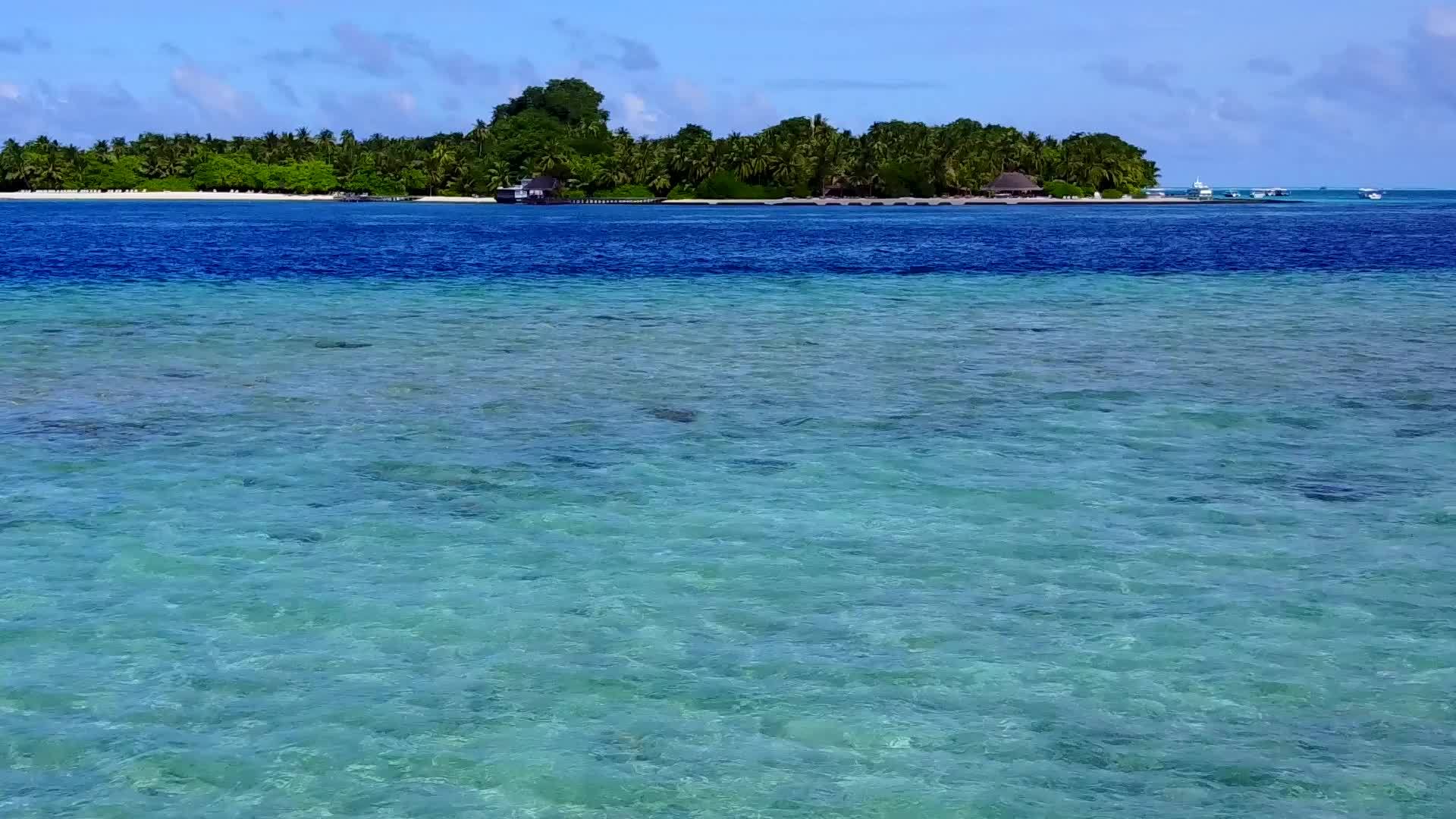 在蓝色的海滩上放松度假胜地日落前有白色的沙滩背景视频的预览图