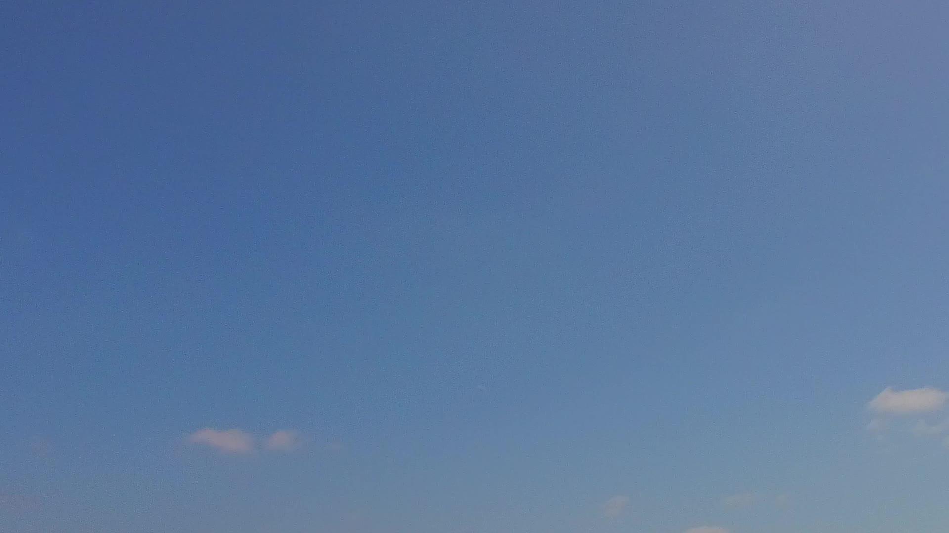 日落前热带海岸海滩在白色海滩的背景下沿着蓝海航行天气晴朗视频的预览图